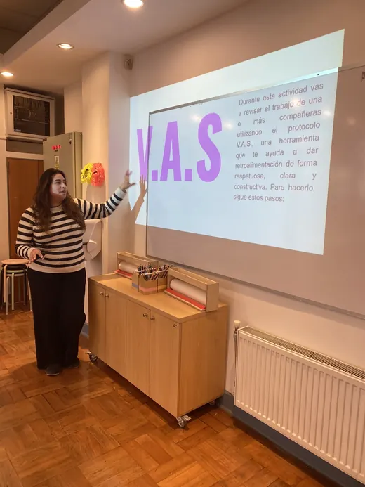 Cote frente a una proyección que dice V.A.S., explicando la actividad